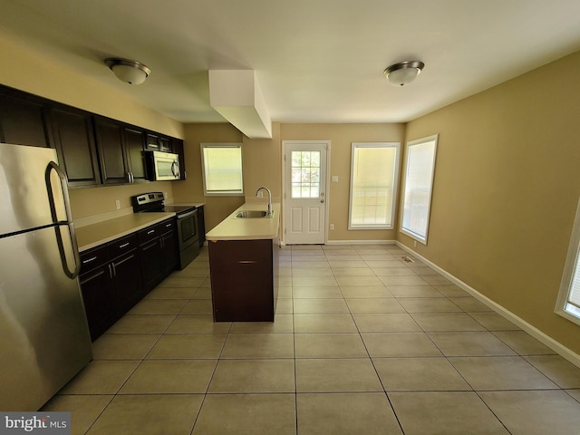 216 Parker Ave, Philadelphia, PA 19128 - kitchen featuring stainless steel appliances, a sink, light countertops, light tile patterned floors, and baseboards