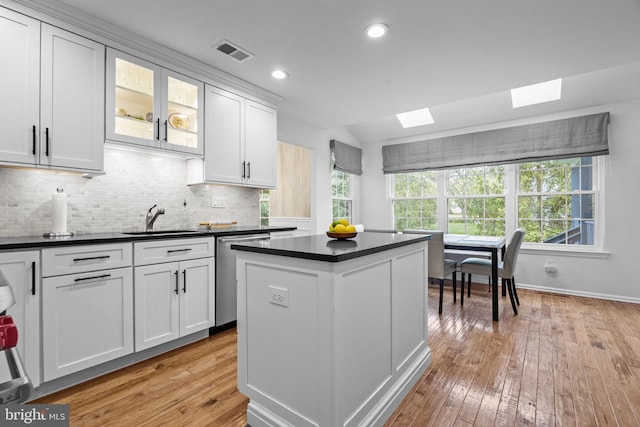 33 Jonquil Dr, Newtown, PA 18940 - kitchen with dishwasher, a sink, a skylight, dark countertops, and light wood finished floors