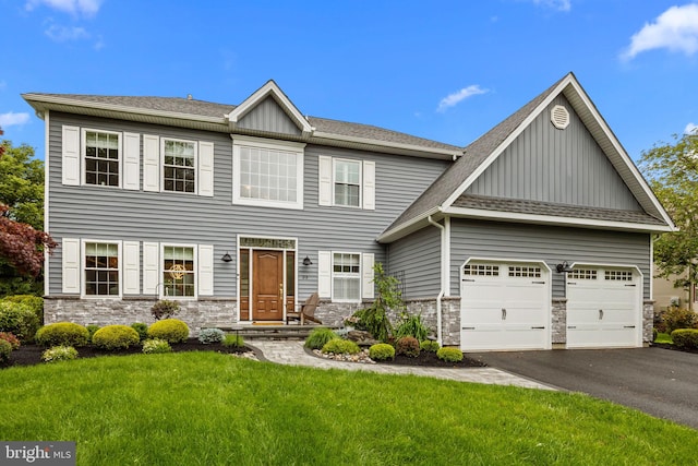 33 Jonquil Dr, Newtown, PA 18940 - view of front of house featuring board and batten siding, driveway, stone siding, a garage, and a front lawn