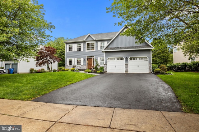33 Jonquil Dr, Newtown, PA 18940 - view of front facade featuring asphalt driveway, stone siding, board and batten siding, and a front lawn