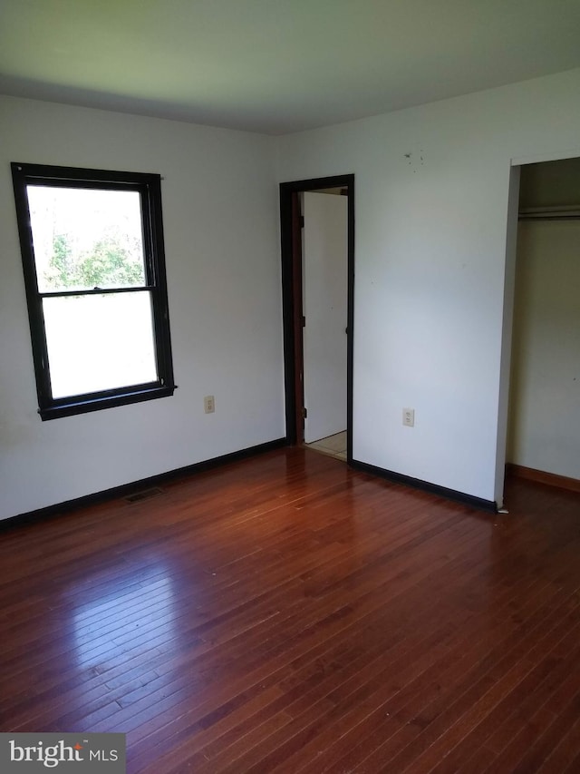 9438 Waterford Dr, Manassas, VA 20110 - unfurnished bedroom featuring dark wood-type flooring and baseboards