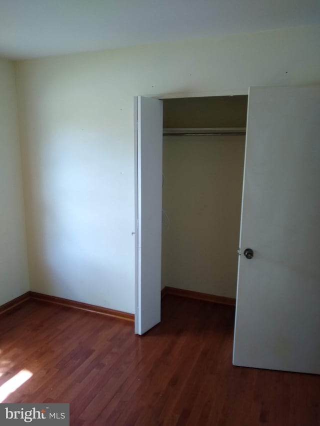 9438 Waterford Dr, Manassas, VA 20110 - unfurnished bedroom with wood finished floors, a closet, and baseboards
