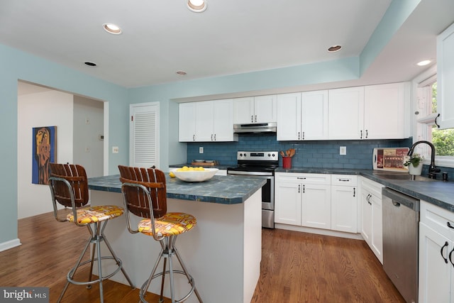 9 Laurel Wood, Lawrenceville, NJ 08648 - kitchen with appliances with stainless steel finishes, dark countertops, a sink, a kitchen breakfast bar, and recessed lighting
