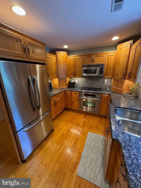 457 Langley Rd, Pittsgrove, NJ 08318 - kitchen with stainless steel appliances, brown cabinets, tasteful backsplash, light wood finished floors, and recessed lighting
