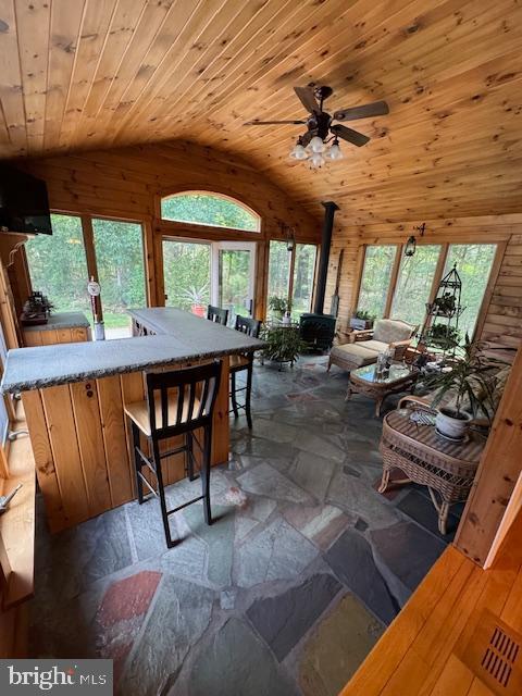 457 Langley Rd, Pittsgrove, NJ 08318 - dining area featuring lofted ceiling, a wood stove, stone tile floors, wood ceiling, and a ceiling fan