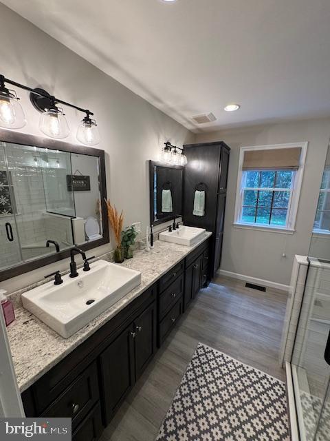 457 Langley Rd, Pittsgrove, NJ 08318 - bathroom featuring double vanity, a stall shower, wood finished floors, baseboards, and recessed lighting