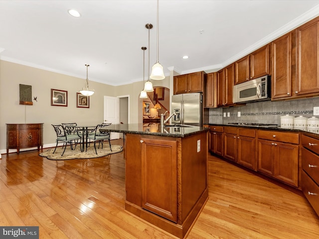 2507 Island Grove Blvd, Frederick, MD 21701 - kitchen with stainless steel appliances, ornamental molding, backsplash, light wood-style floors, and decorative light fixtures