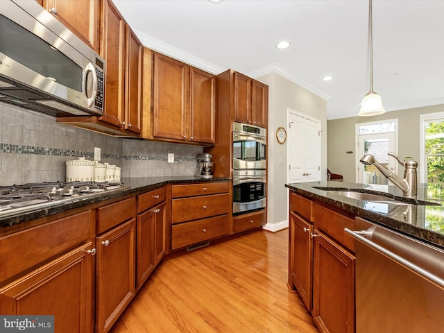 2507 Island Grove Blvd, Frederick, MD 21701 - kitchen with appliances with stainless steel finishes, a sink, light wood finished floors, brown cabinetry, and pendant lighting