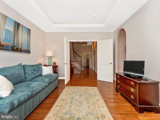 2507 Island Grove Blvd, Frederick, MD 21701 - living room featuring arched walkways, wood finished floors, a tray ceiling, stairway, and baseboards