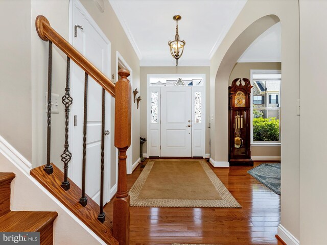 2507 Island Grove Blvd, Frederick, MD 21701 - entrance foyer featuring crown molding, wood finished floors, arched walkways, stairs, and baseboards