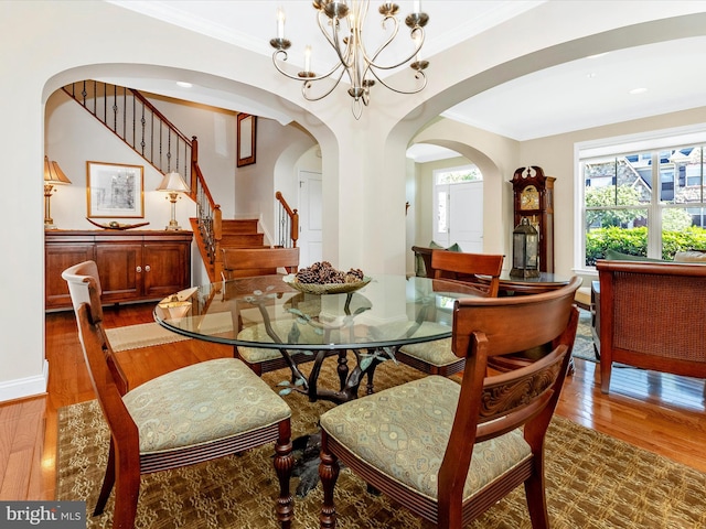 2507 Island Grove Blvd, Frederick, MD 21701 - dining room featuring wood finished floors, arched walkways, crown molding, a chandelier, and stairs