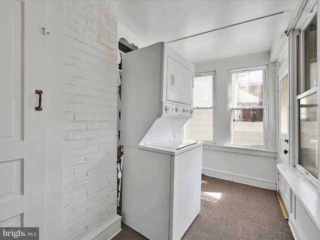 138 W Main St, Schuylkill Haven, PA 17972 - washroom with estacked washer and dryer, dark colored carpet, brick wall, and baseboards