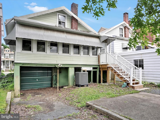 138 W Main St, Schuylkill Haven, PA 17972 - view of front of property with central AC unit, an attached garage, driveway, a chimney, and stairway