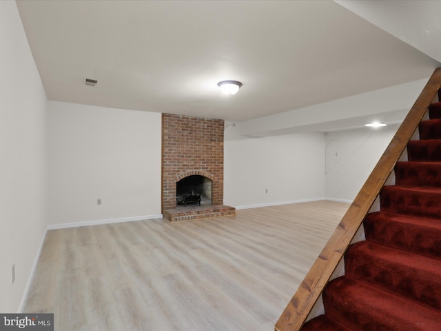 7449 Maple Branch Rd, Clifton, VA 20124 - unfurnished living room with wood finished floors, stairway, baseboards, and a brick fireplace