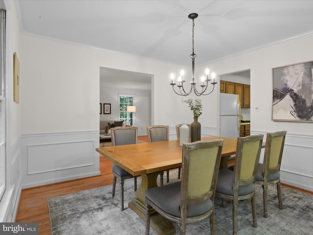 7449 Maple Branch Rd, Clifton, VA 20124 - dining room featuring light wood-type flooring, a chandelier, crown molding, a wainscoted wall, and a decorative wall