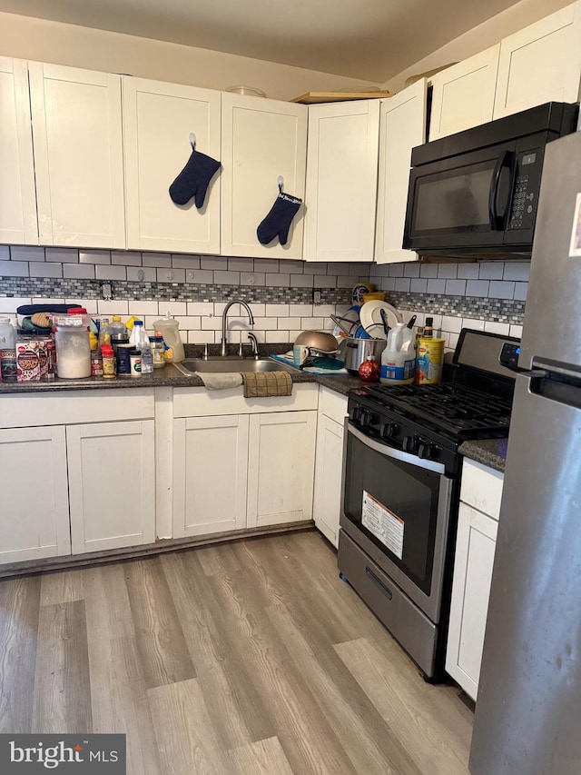 3141 W Norris St, Philadelphia, PA 19121 - kitchen featuring appliances with stainless steel finishes, a sink, dark countertops, and tasteful backsplash