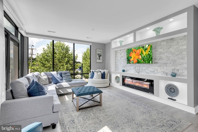 145 Riverhaven Dr Unit 313, Oxon Hill, MD 20745 - living area with wood finished floors, a glass covered fireplace, and a wall of windows