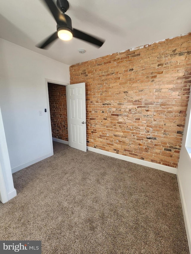 2218 Ruskin Ave, Baltimore, MD 21217 - spare room with ceiling fan, baseboards, brick wall, and carpet floors