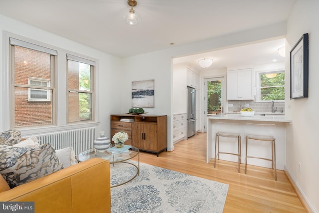 3709 Jocelyn St NW, Washington, DC 20015 - living area featuring radiator heating unit, light wood finished floors, and healthy amount of natural light