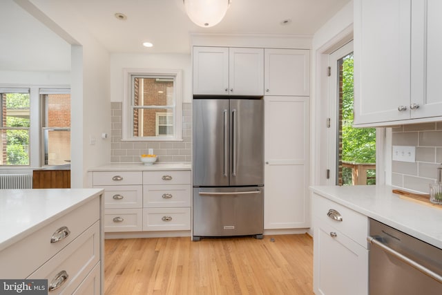 3709 Jocelyn St NW, Washington, DC 20015 - kitchen featuring appliances with stainless steel finishes, radiator heating unit, light countertops, backsplash, and recessed lighting