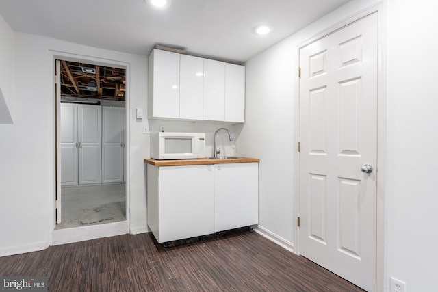 3709 Jocelyn St NW, Washington, DC 20015 - kitchen with white microwave, white cabinetry, dark wood-type flooring, a sink, and recessed lighting
