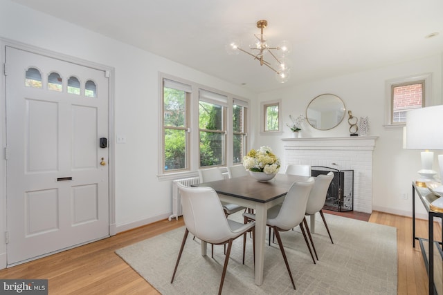3709 Jocelyn St NW, Washington, DC 20015 - dining space featuring a chandelier, light wood-type flooring, a fireplace, baseboards, and radiator heating unit