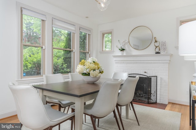 3709 Jocelyn St NW, Washington, DC 20015 - dining room with wood finished floors, a brick fireplace, and baseboards