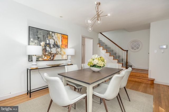 3709 Jocelyn St NW, Washington, DC 20015 - dining area featuring stairs, light wood-style flooring, a chandelier, and baseboards