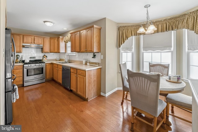 1219 N Valley Ave, Vineland, NJ 08360 - kitchen featuring appliances with stainless steel finishes, under cabinet range hood, a chandelier, a sink, and light countertops
