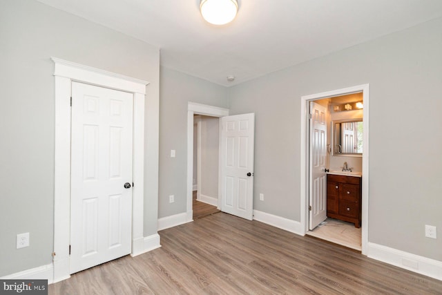 3327 Richmond Ave, Baltimore, MD 21213 - unfurnished bedroom with wood finished floors, baseboards, ensuite bathroom, and a sink