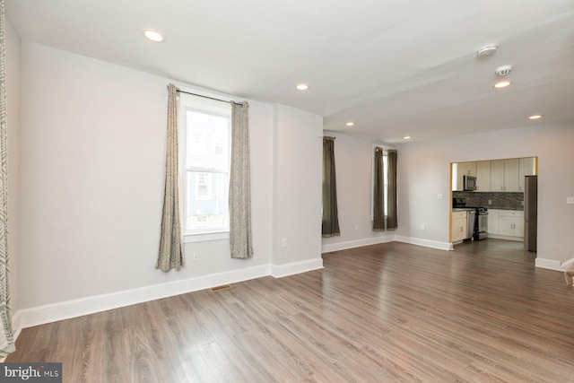3327 Richmond Ave, Baltimore, MD 21213 - unfurnished living room featuring wood finished floors, baseboards, and recessed lighting