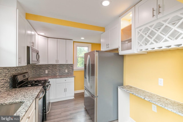 3327 Richmond Ave, Baltimore, MD 21213 - kitchen with stainless steel appliances, light wood-style flooring, white cabinetry, backsplash, and light stone countertops