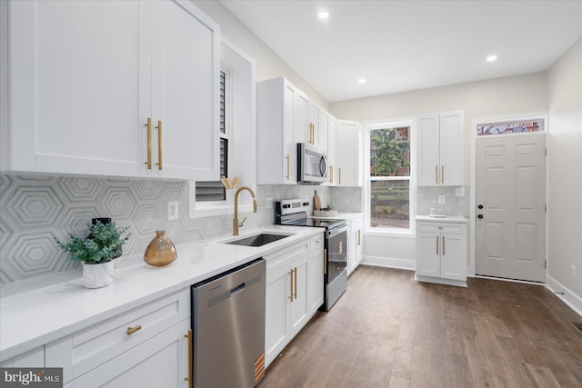 724 E 21st St, Baltimore, MD 21218 - kitchen featuring appliances with stainless steel finishes, a sink, white cabinetry, dark wood-style floors, and decorative backsplash