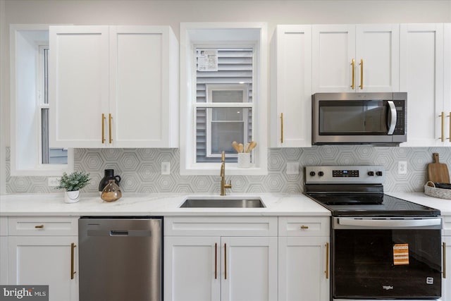 724 E 21st St, Baltimore, MD 21218 - kitchen featuring appliances with stainless steel finishes, a sink, tasteful backsplash, and white cabinetry