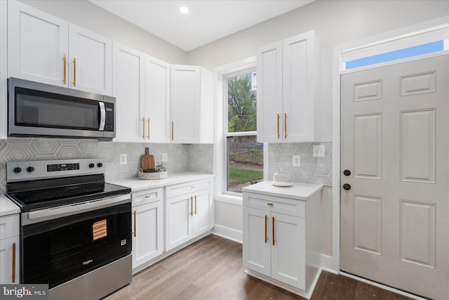 724 E 21st St, Baltimore, MD 21218 - kitchen with appliances with stainless steel finishes, light countertops, white cabinetry, and backsplash