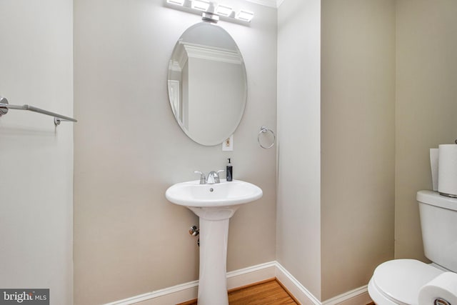 8524 Schultz Rd, Clinton, MD 20735 - half bath with toilet, baseboards, a sink, and wood finished floors