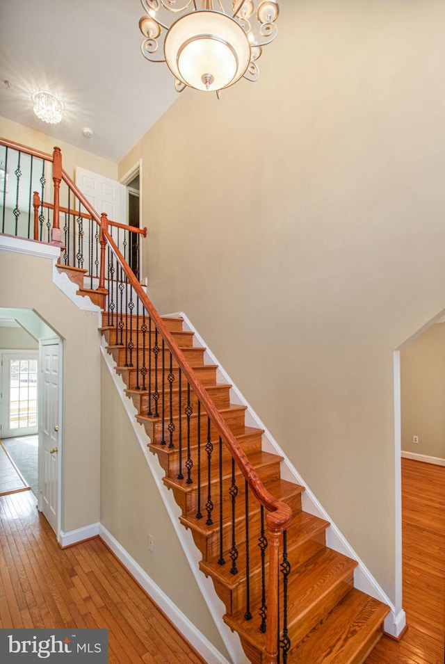 8524 Schultz Rd, Clinton, MD 20735 - staircase with wood-type flooring, baseboards, and a chandelier