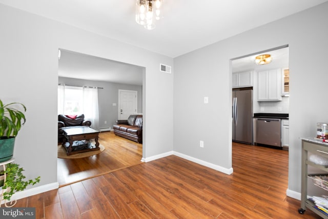 1704 Horner Rd, Woodbridge, VA 22191 - hall featuring wood finished floors, baseboards, and a baseboard heating unit