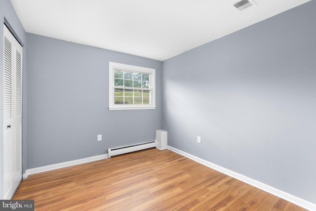 1704 Horner Rd, Woodbridge, VA 22191 - unfurnished bedroom featuring a baseboard radiator, a closet, light wood-type flooring, and baseboards