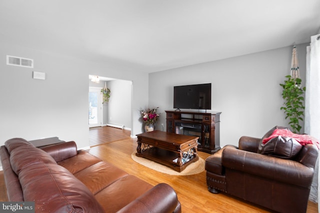 1704 Horner Rd, Woodbridge, VA 22191 - living area with a baseboard heating unit, light wood-type flooring, and a fireplace