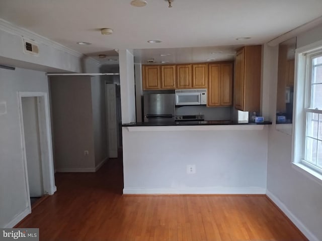 4202 Grant St NE Unit 202, Washington, DC 20019 - kitchen with white microwave, freestanding refrigerator, range with electric stovetop, dark countertops, and wood finished floors