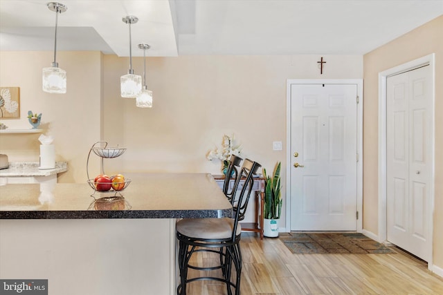 649 Brandon Rd, Eagleville, PA 19403 - kitchen featuring light wood-type flooring, a kitchen breakfast bar, baseboards, and pendant lighting