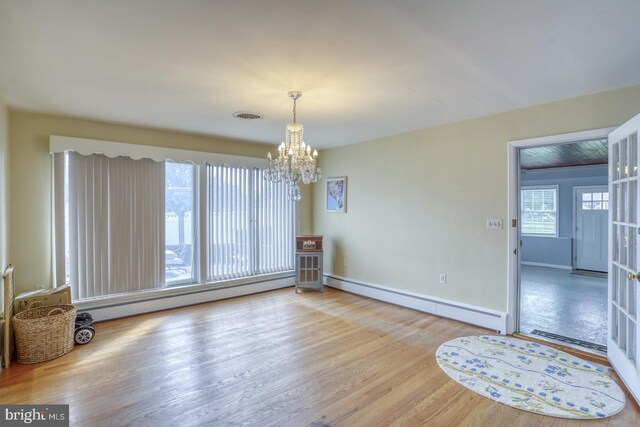 333 S School Ln, Smyrna, DE 19977 - unfurnished dining area with a baseboard heating unit, a chandelier, and wood finished floors