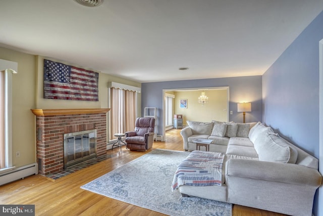 333 S School Ln, Smyrna, DE 19977 - living room featuring a fireplace, a baseboard heating unit, wood finished floors, a chandelier, and baseboard heating