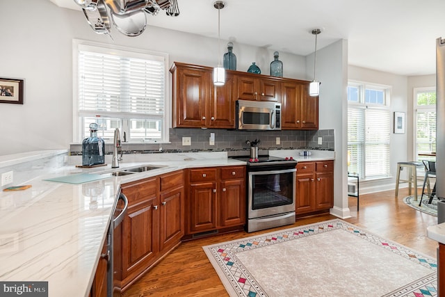 1430 Amherst Ct, Mechanicsburg, PA 17050 - kitchen with stainless steel appliances, a sink, light wood-type flooring, tasteful backsplash, and brown cabinets