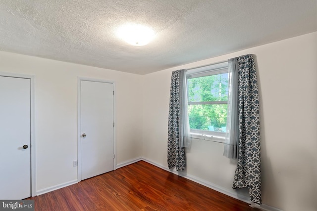 9615 51st Pl, College Park, MD 20740 - unfurnished bedroom featuring wood finished floors, a textured ceiling, and baseboards