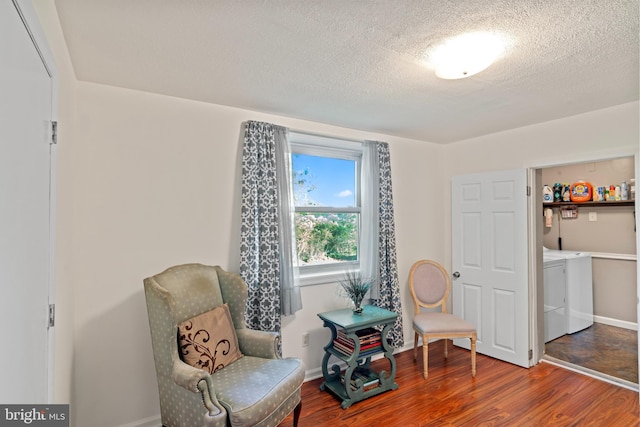 9615 51st Pl, College Park, MD 20740 - living area with washing machine and clothes dryer, wood finished floors, baseboards, and a textured ceiling