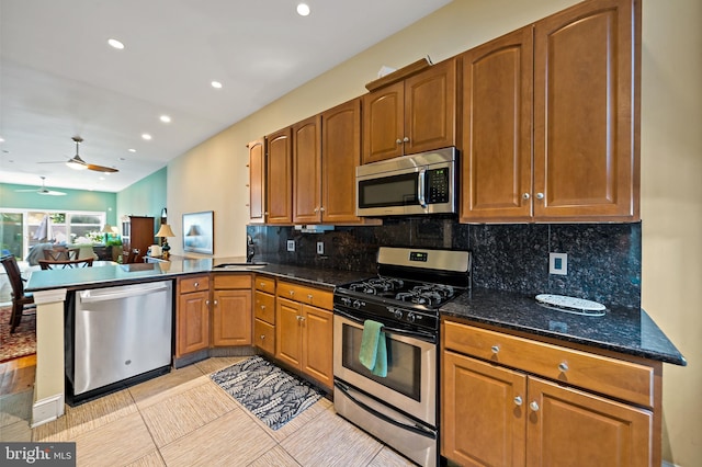 1812 Fairmount Ave, Philadelphia, PA 19130 - kitchen featuring stainless steel appliances, a peninsula, ceiling fan, decorative backsplash, and dark stone counters