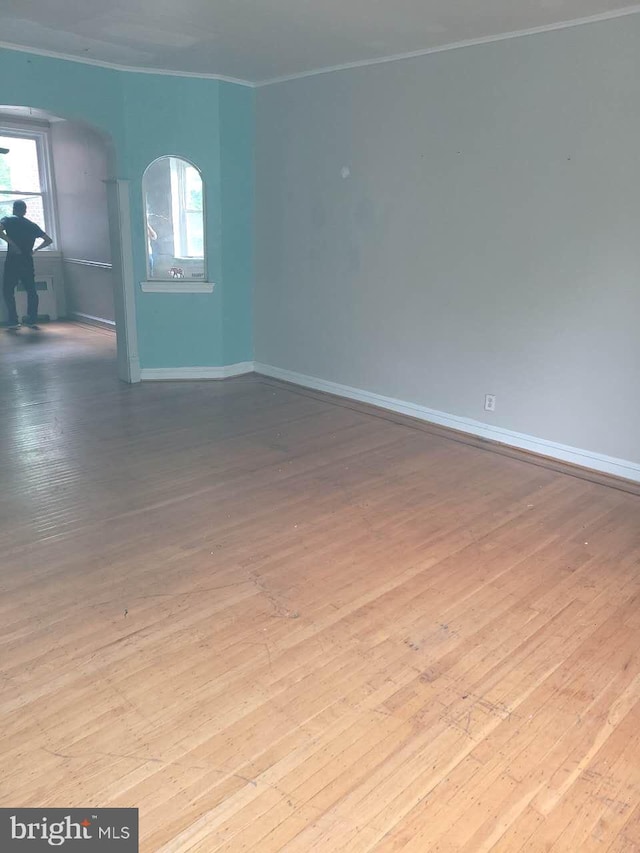 5137 D St, Philadelphia, PA 19120 - spare room featuring crown molding, hardwood / wood-style floors, baseboards, and arched walkways