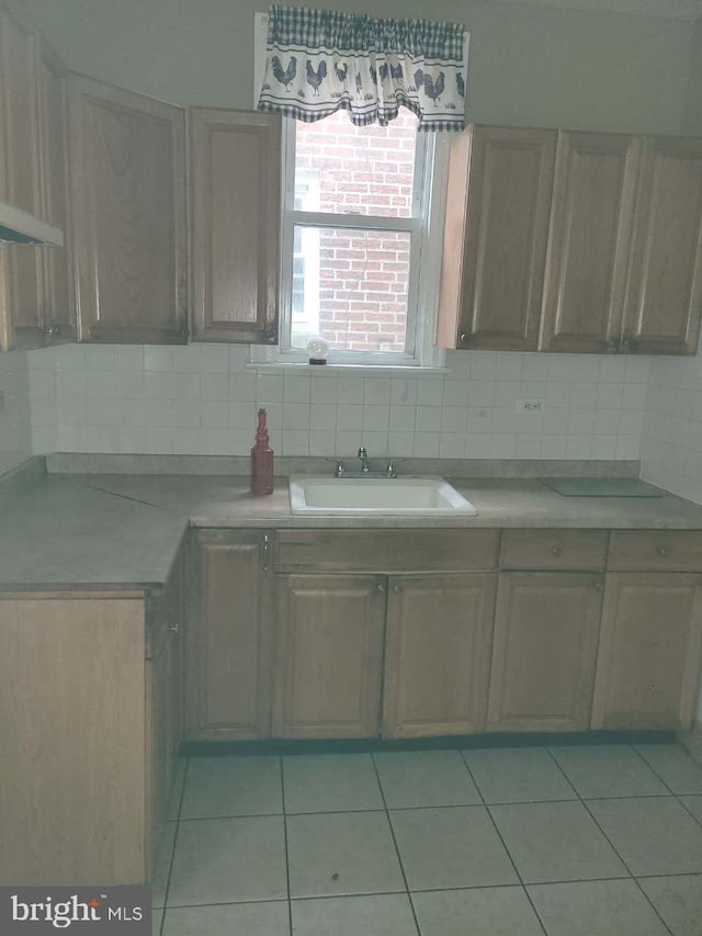 5137 D St, Philadelphia, PA 19120 - kitchen with a sink, light countertops, light tile patterned flooring, backsplash, and wall chimney exhaust hood